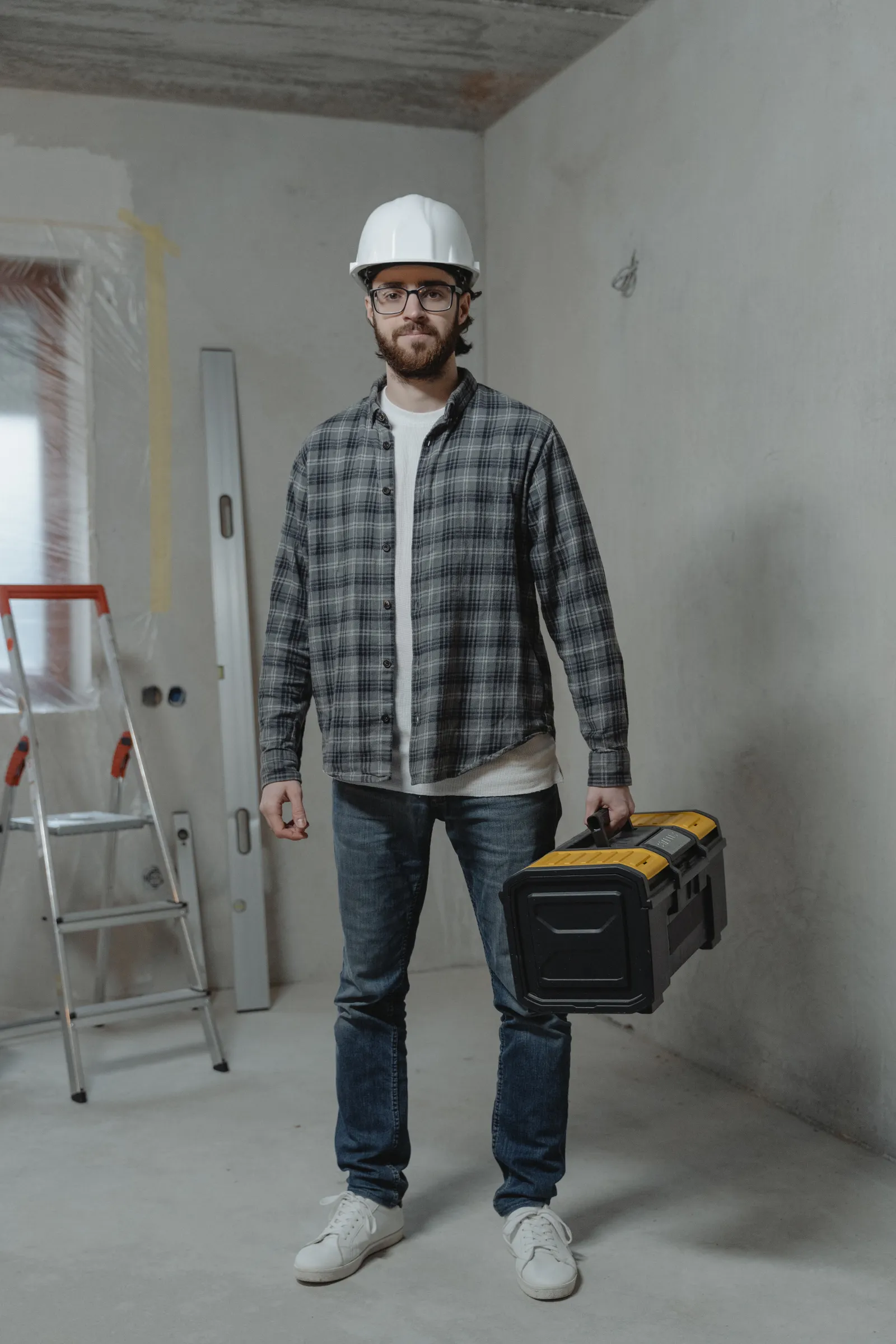 Professionnel avec boîte à outils dans un logement en rénovation