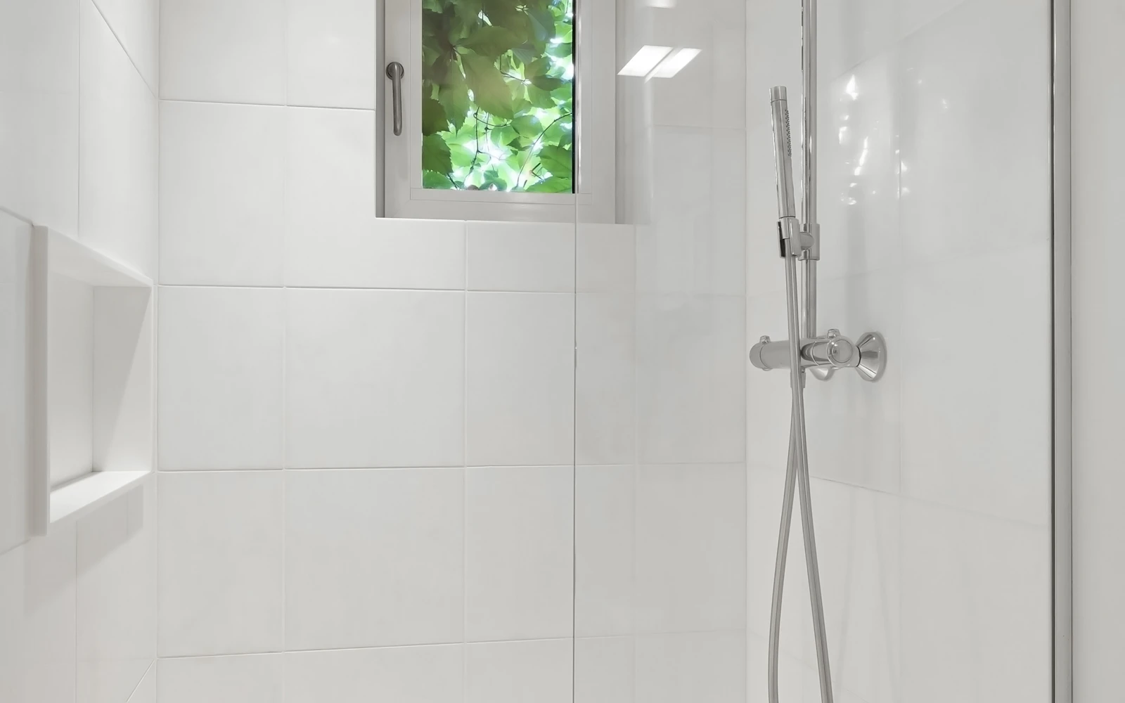 Douche à l’italienne moderne avec paroi vitrée et receveur discret