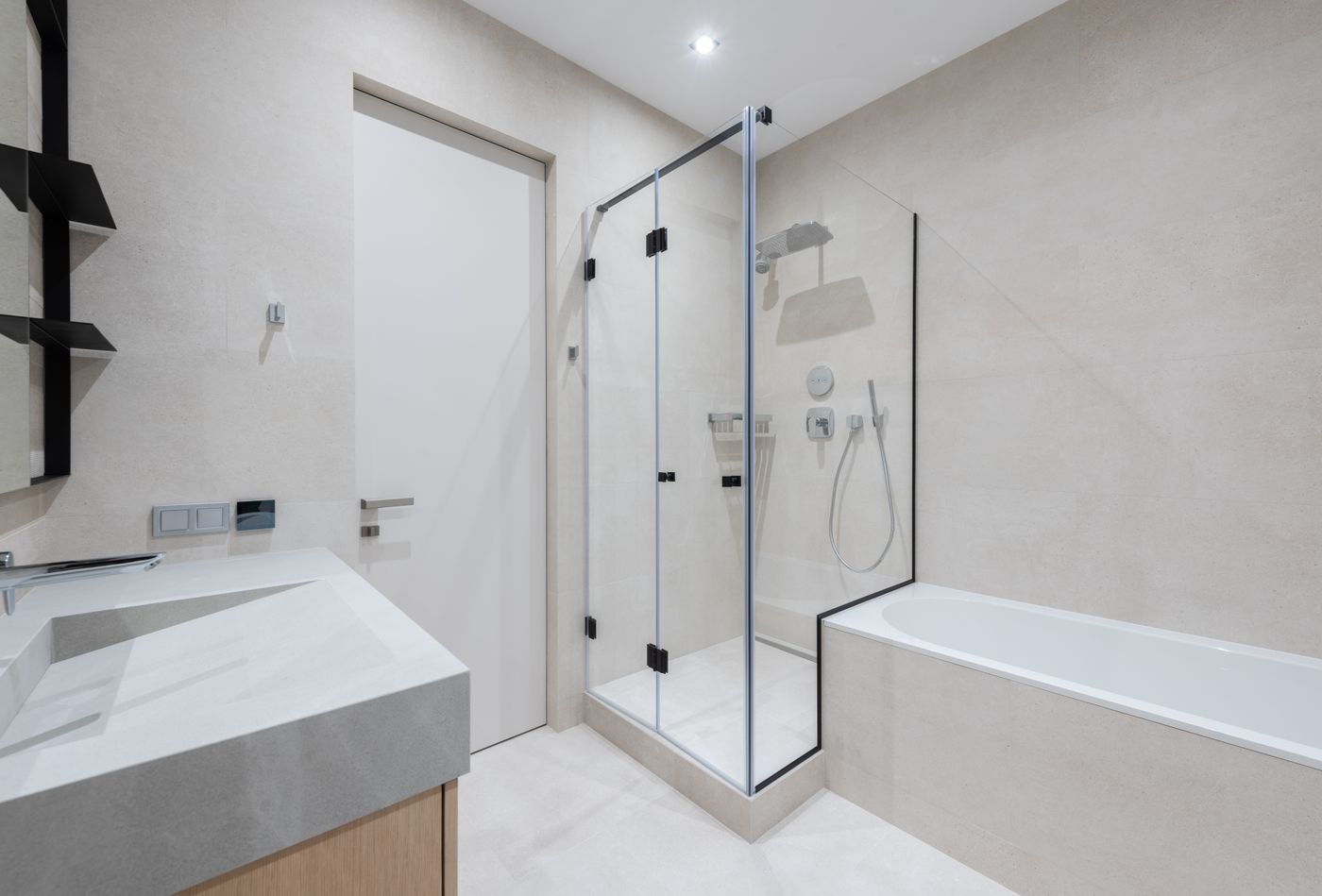 Salle de bain organisée avec douche vitrée, baignoire et vasque