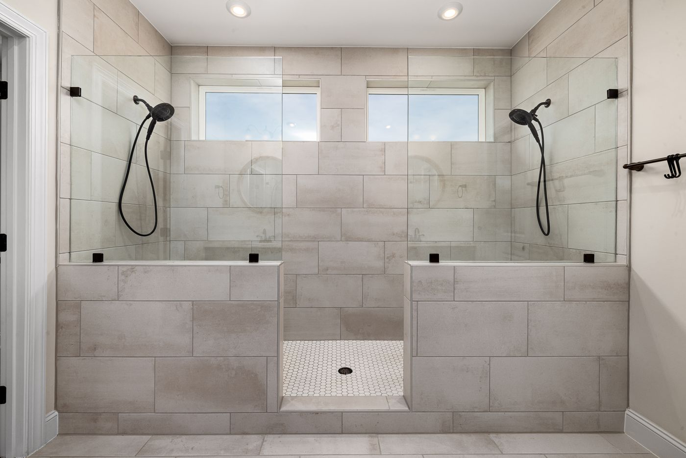 Douche carrelée avec grands carreaux muraux et sol mosaïque