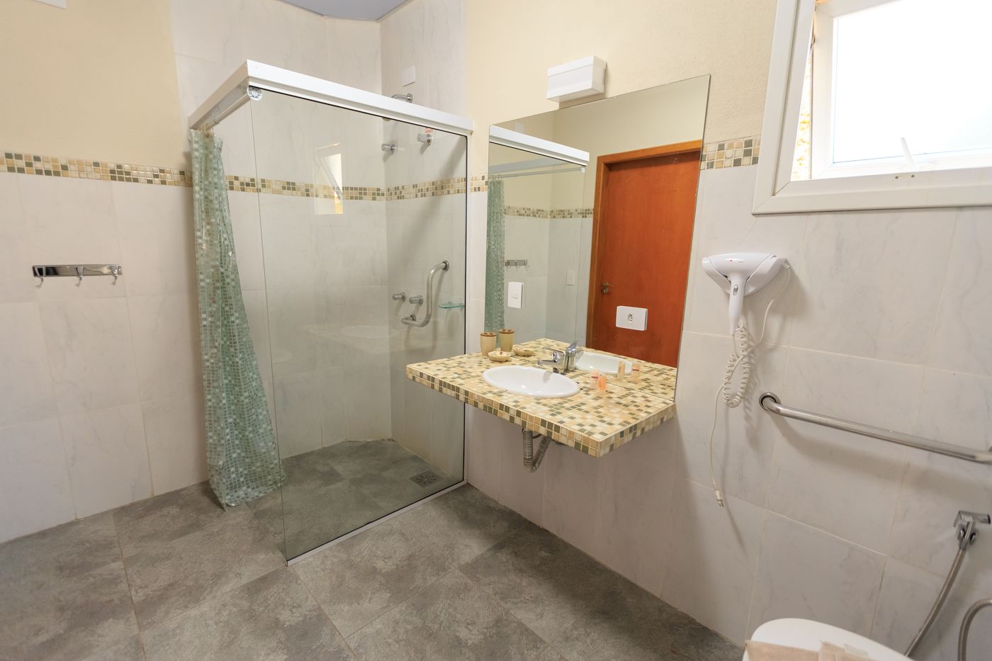 Salle de bain accessible avec douche de plain-pied et barre d’appui